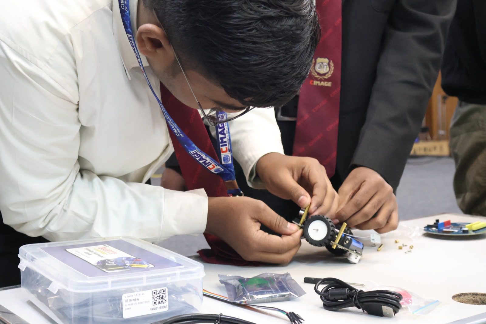 Student assembling an IIT-Bombay e-Yantra robotics kit at CIMAGE