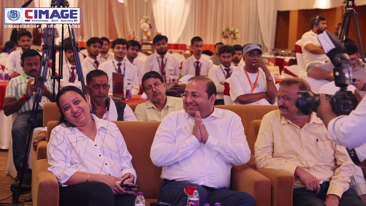 Guests and students are seated in an auditorium listening attentively to a session.